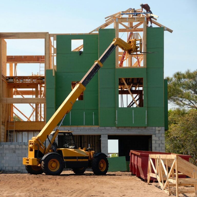 Yellow and Black Heavy Equipment Near Unfinished Building